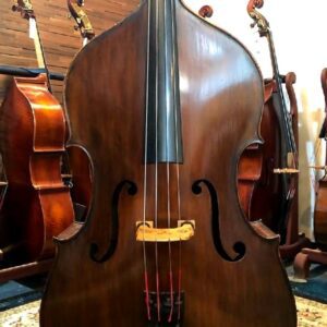 A varnished double bass and a set of double basses behind