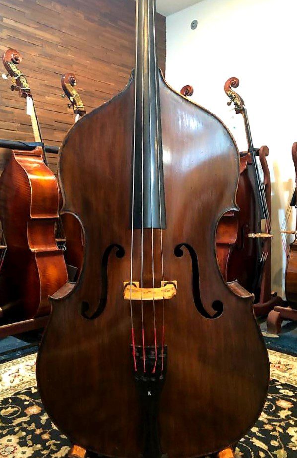A varnished double bass and a set of double basses behind